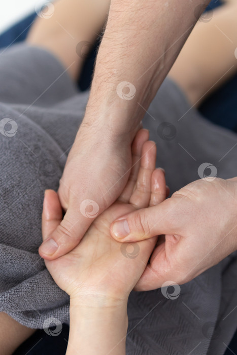 Скачать Массаж рук крупным планом.Профессиональный массажист делает женщине массаж рук фотосток Ozero