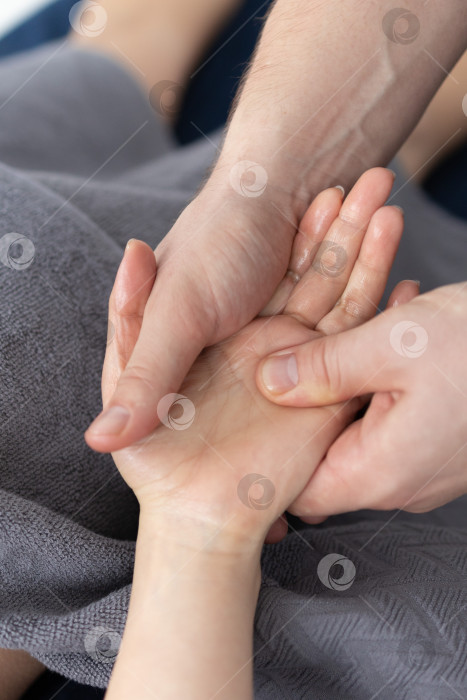 Скачать Массаж рук крупным планом.Профессиональный массажист делает женщине массаж рук фотосток Ozero