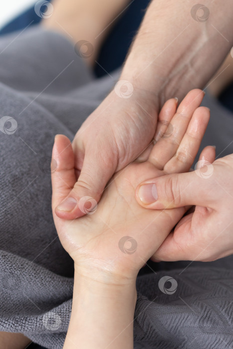 Скачать Массаж рук крупным планом.Профессиональный массажист делает женщине массаж рук фотосток Ozero