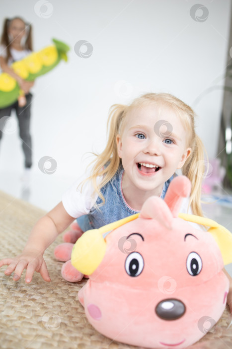 Скачать Счастливая девочка с мягкой игрушкой на белом фоне фотосток Ozero