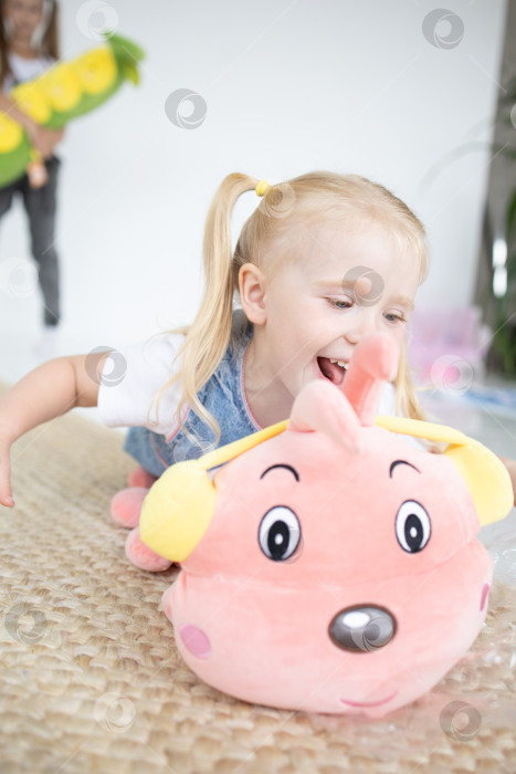 Скачать Счастливая девочка с мягкой игрушкой на белом фоне фотосток Ozero