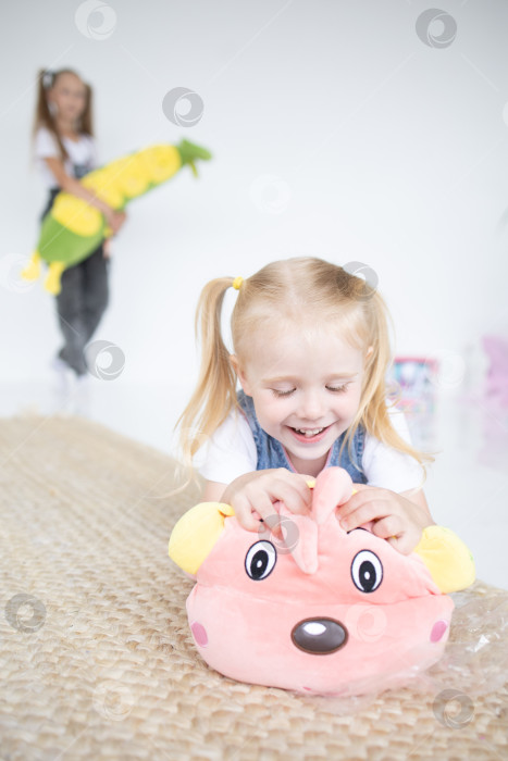 Скачать Счастливая девочка с мягкой игрушкой на белом фоне фотосток Ozero