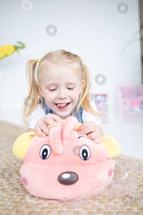 Скачать Счастливая девочка с мягкой игрушкой на белом фоне фотосток Ozero