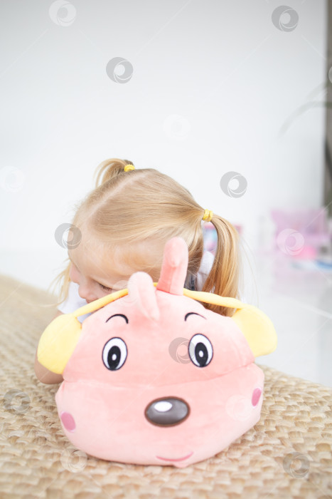 Скачать Счастливая девочка с мягкой игрушкой на белом фоне фотосток Ozero