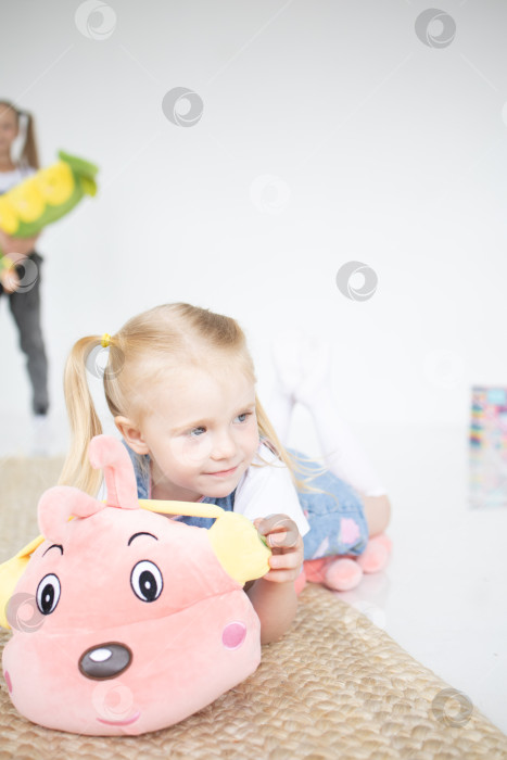 Скачать Счастливая девочка с мягкой игрушкой на белом фоне фотосток Ozero