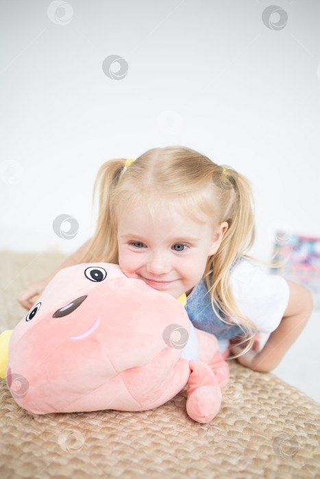 Скачать Счастливая девочка с мягкой игрушкой на белом фоне фотосток Ozero
