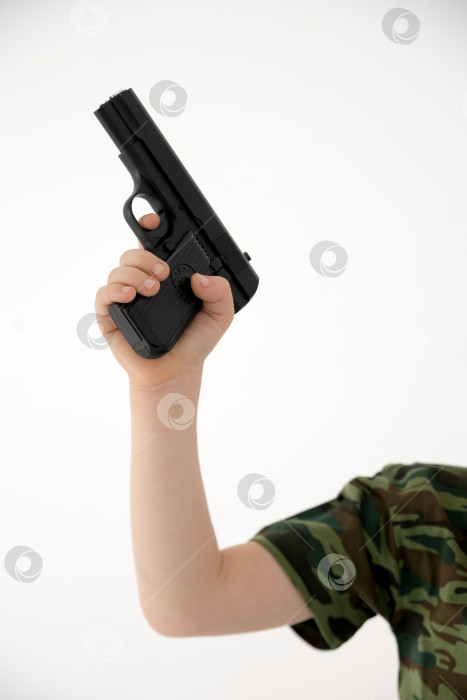 Скачать Крупным планом мужская рука, держащая черный пластиковый игрушечный пистолет на белом фоне.игрушечный пистолет в руке НА БЕЛОМ ФОНЕ фотосток Ozero