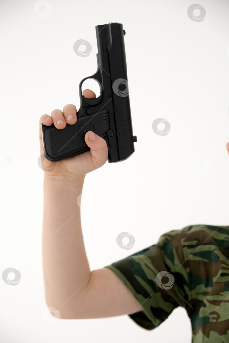 Скачать Крупным планом мужская рука, держащая черный пластиковый игрушечный пистолет на белом фоне.игрушечный пистолет в руке НА БЕЛОМ ФОНЕ фотосток Ozero