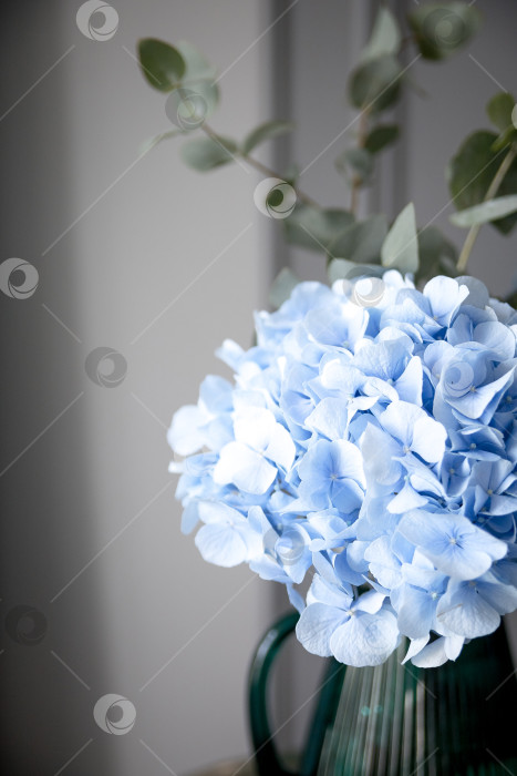 Скачать Искусственный букет из розовых и фиолетовых гортензий на столике в кафе. Солнце отбрасывает тени фотосток Ozero