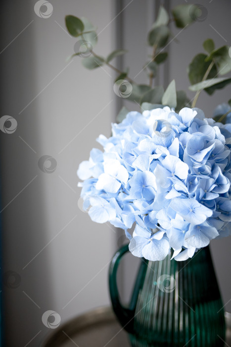 Скачать Искусственный букет из розовых и фиолетовых гортензий на столике в кафе. Солнце отбрасывает тени фотосток Ozero