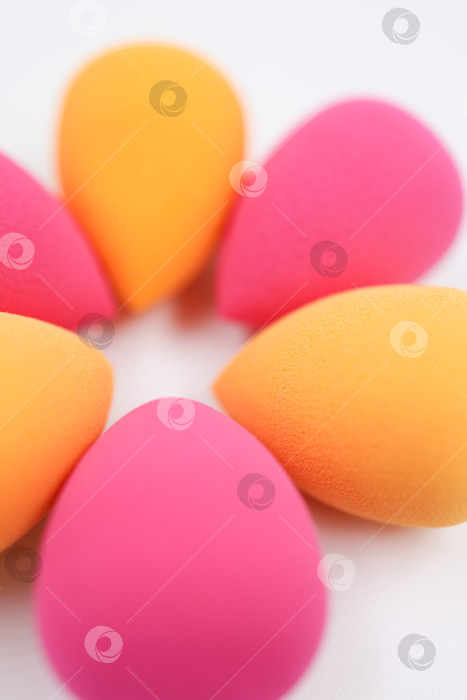 Скачать розовые и оранжевые косметические губки на светлом деревянном фоне, фотосток Ozero