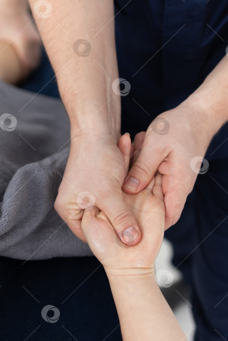 Скачать Массаж рук крупным планом.Профессиональный массажист делает женщине массаж рук фотосток Ozero