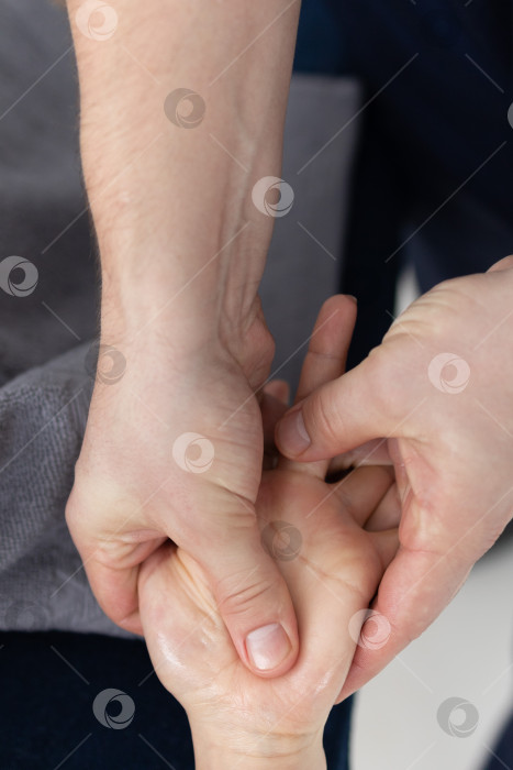 Скачать Массаж рук крупным планом.Профессиональный массажист делает женщине массаж рук фотосток Ozero