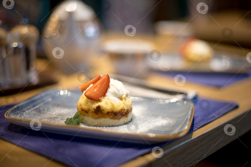Скачать Десерт с клубникой в ресторане на голубой тарелке фотосток Ozero