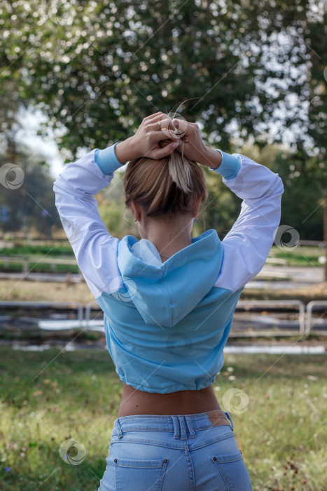 Скачать Молодая девушка в спортивной синей толстовке с капюшоном на открытом воздухе фотосток Ozero