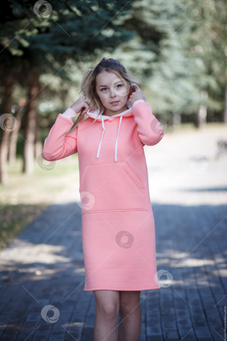 Скачать Улыбающаяся девушка в розовом спортивном платье смотрит в камеру фотосток Ozero
