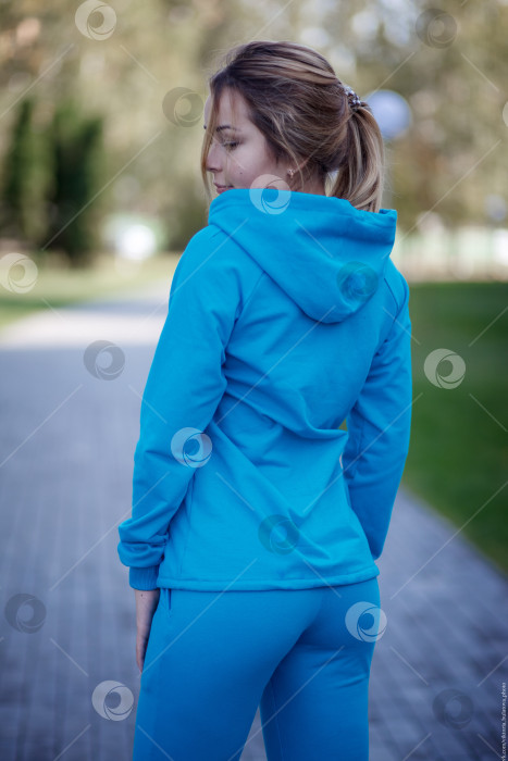 Скачать Улыбающаяся девушка в синем спортивном костюме на улице смотрит в камеру фотосток Ozero