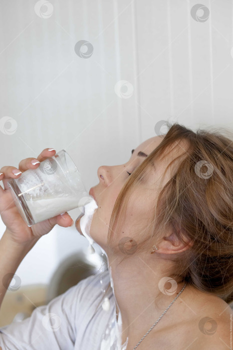 Скачать Женщина пьет молоко и проливает его себе на шею фотосток Ozero