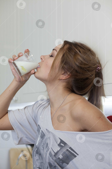 Скачать Женщина пьет молоко и проливает его себе на шею фотосток Ozero