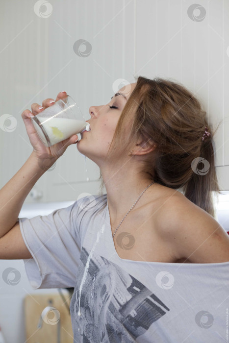 Скачать Женщина пьет молоко и проливает его себе на шею фотосток Ozero