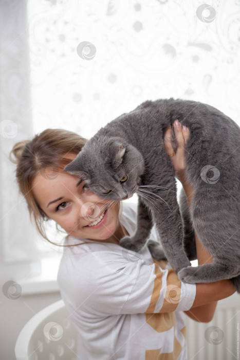 Скачать Женщина и кошка лежат на кровати на белом покрывале фотосток Ozero