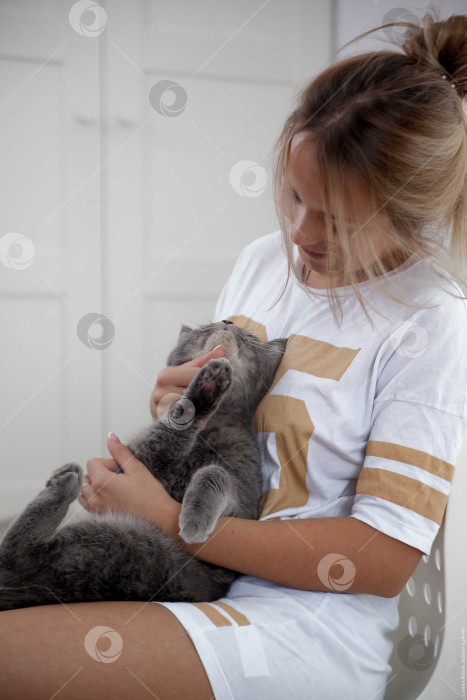 Скачать Женщина и кошка лежат на кровати на белом покрывале фотосток Ozero