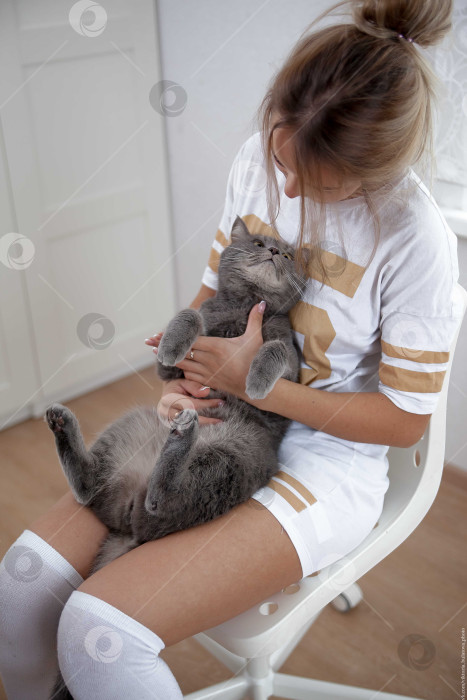 Скачать Женщина и кошка лежат на кровати на белом покрывале фотосток Ozero