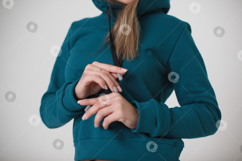 Скачать Женщина в синем спортивном костюме на белом фоне смотрит в камеру фотосток Ozero