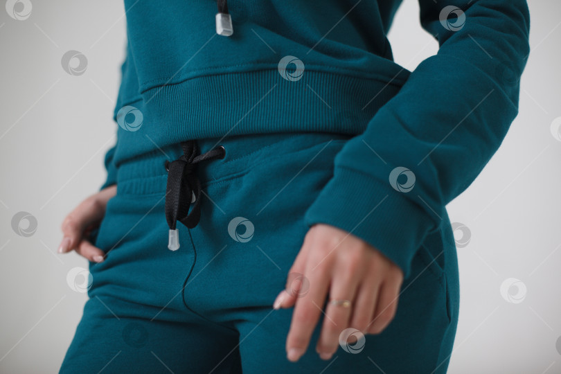 Скачать Женщина в синем спортивном костюме на белом фоне смотрит в камеру фотосток Ozero