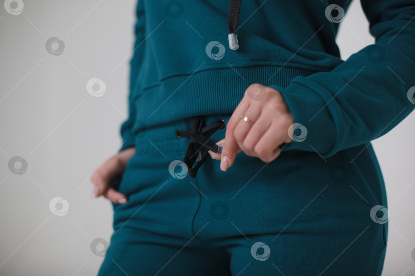 Скачать Женщина в синем спортивном костюме на белом фоне смотрит в камеру фотосток Ozero