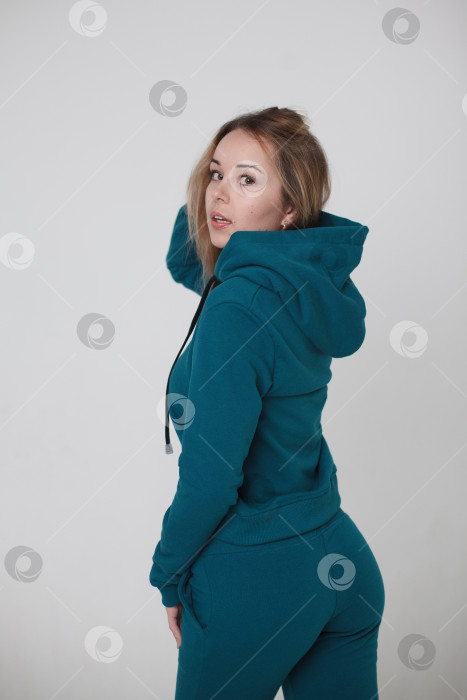 Скачать Женщина в синем спортивном костюме на белом фоне смотрит в камеру фотосток Ozero