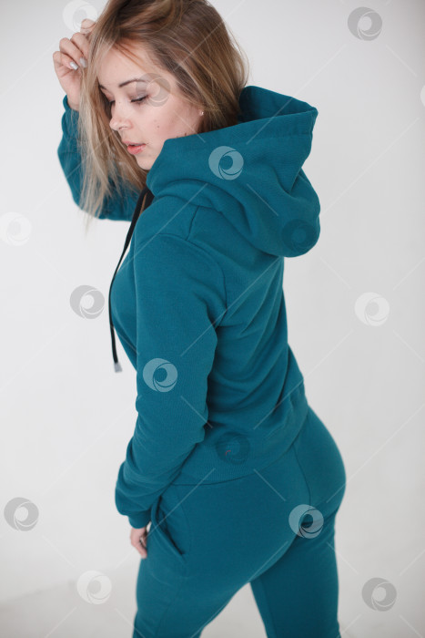 Скачать Женщина в фиолетовом спортивном костюме на белом фоне смотрит в камеру фотосток Ozero