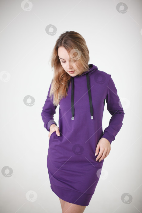 Скачать Женщина в фиолетовом спортивном костюме на белом фоне смотрит в камеру фотосток Ozero