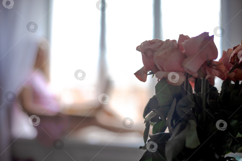 Скачать Букет роз на переднем плане. место для надписи. Размытая женская фигура на заднем плане фотосток Ozero