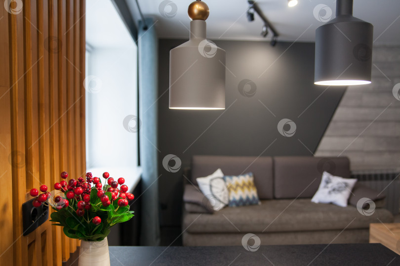 Скачать Серый диван с одеялом, подушкой, деревянным журнальным столиком и растением на деревянном полу в минималистском интерьере. фотосток Ozero