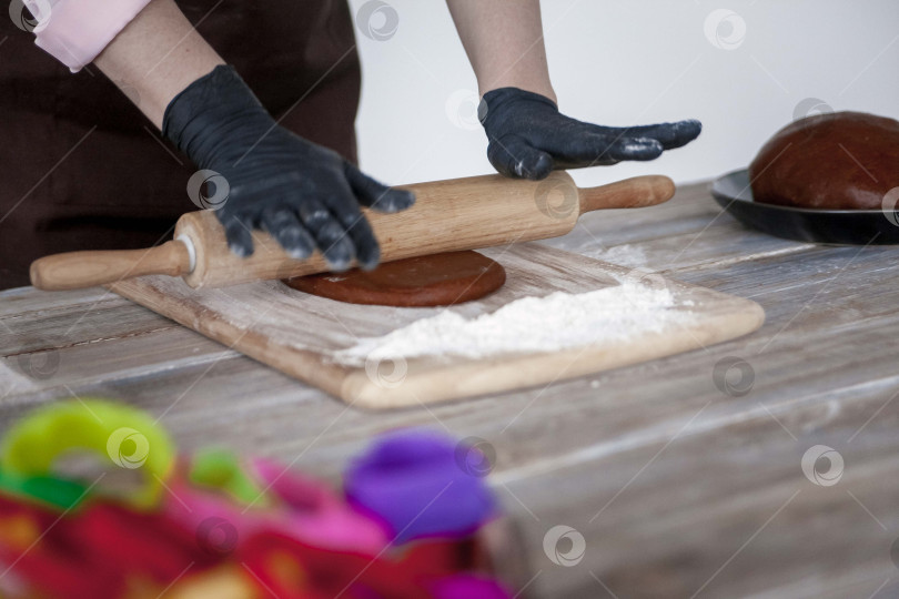 Скачать Сырое пасхальное печенье и формочки для печенья на бумаге для выпечки, вид сверху. Фотографии высокого качества. руки кондитера в перчатках фотосток Ozero