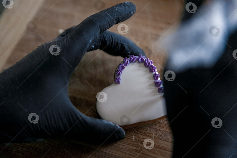 Скачать Сырое пасхальное печенье и формочки для печенья на бумаге для выпечки, вид сверху. Фотографии высокого качества. руки кондитера в перчатках фотосток Ozero