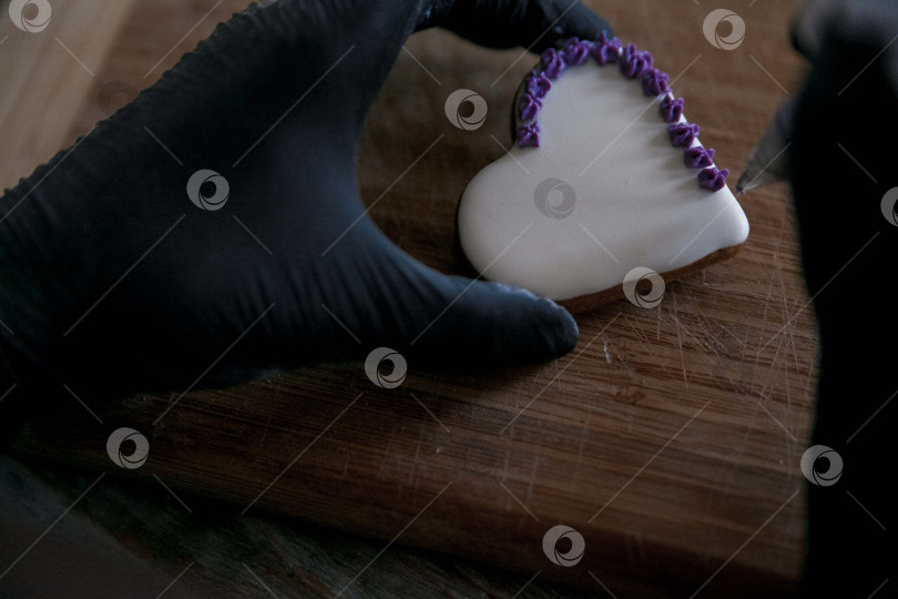 Скачать Сырое пасхальное печенье и формочки для печенья на бумаге для выпечки, вид сверху. Фотографии высокого качества. руки кондитера в перчатках фотосток Ozero