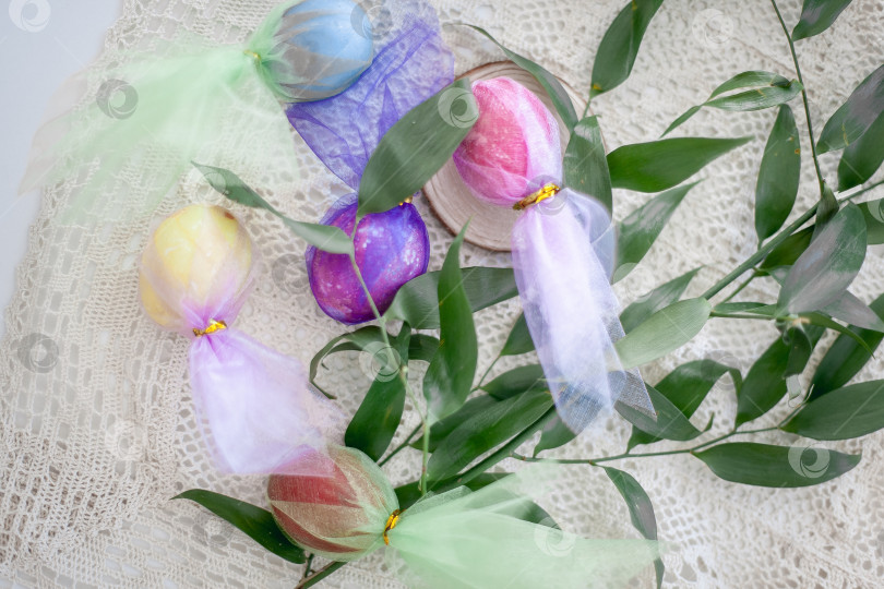Скачать Раскрашенные пасхальные яйца на столе с веточкой растения фотосток Ozero