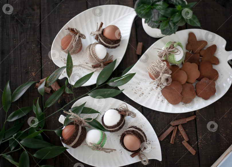 Скачать Пасха. яйца в красивых белых тарелках на темном столе, вид сверху фотосток Ozero