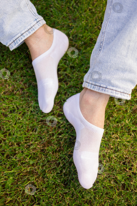 Скачать Мужская нога в белом носке на фоне травы. Мужская нога в носке. фотосток Ozero
