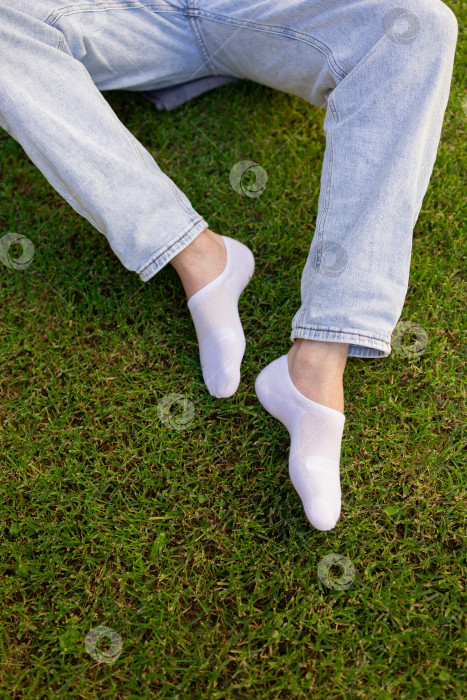 Скачать Мужская нога в белом носке на фоне травы. Мужская нога в носке. фотосток Ozero