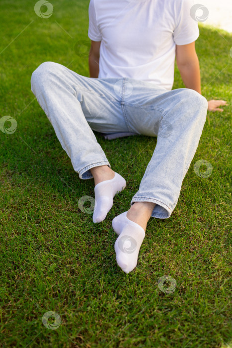 Скачать Мужская нога в белом носке на фоне травы. Мужская нога в носке. фотосток Ozero