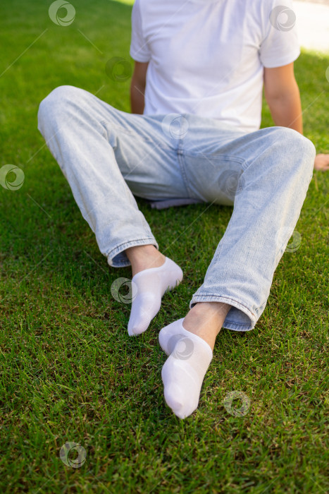 Скачать Мужская нога в белом носке на фоне травы. Мужская нога в носке. фотосток Ozero