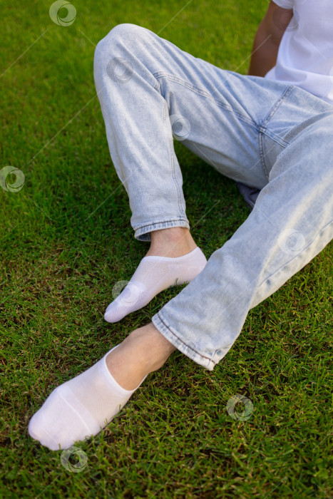 Скачать Мужская нога в белом носке на фоне травы. Мужская нога в носке. фотосток Ozero