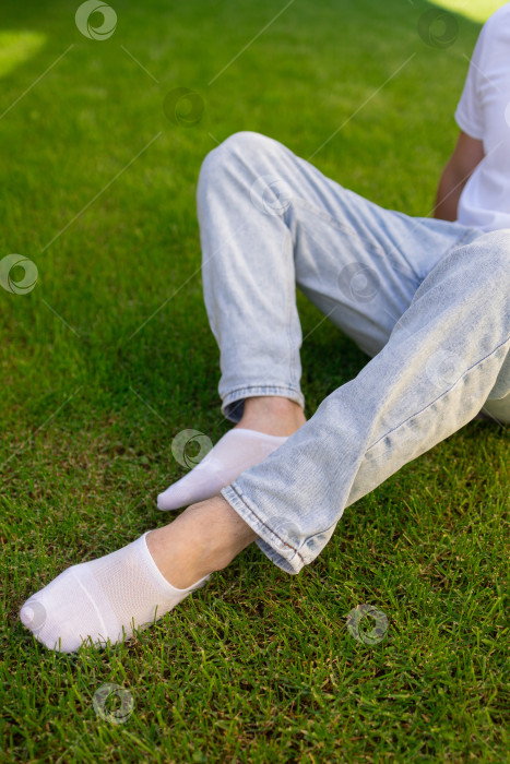 Скачать Мужская нога в белом носке на фоне травы. Мужская нога в носке. фотосток Ozero