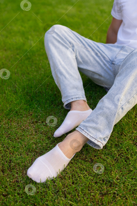 Скачать Мужская нога в белом носке на фоне травы. Мужская нога в носке. фотосток Ozero