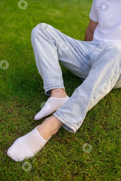 Скачать Мужская нога в белом носке на фоне травы. Мужская нога в носке. фотосток Ozero