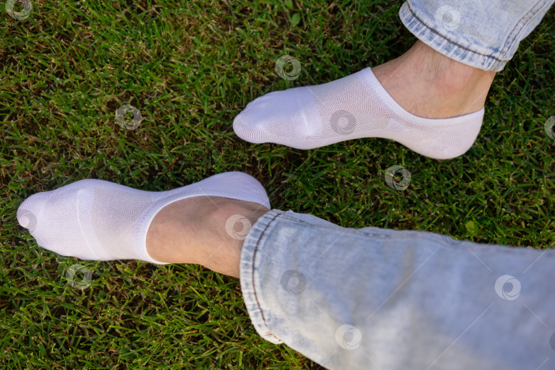 Скачать Мужская нога в белом носке на фоне травы. Мужская нога в носке. фотосток Ozero