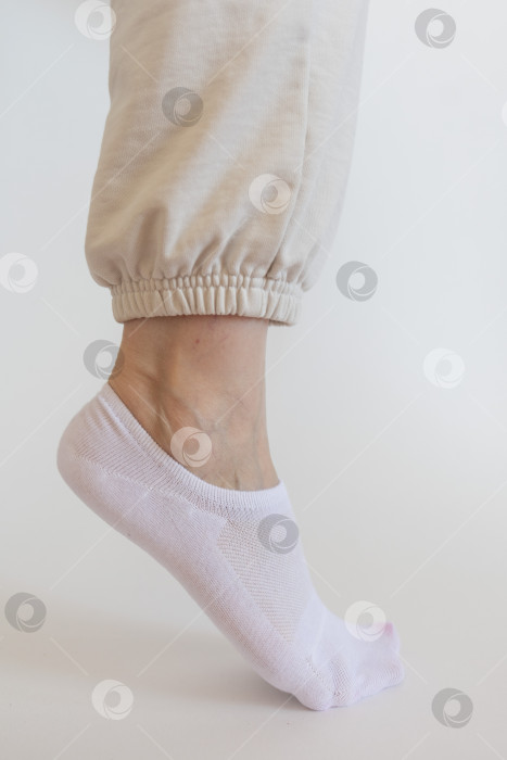 Скачать Женская ножка в белом носке на белом фоне фотосток Ozero